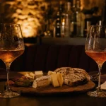 Bar à vin romantique paris, deux verres de vin, lumière douce, planche de fromages